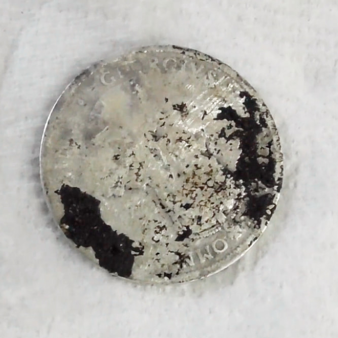 Reverse side of coin in final round of the ultrasonic coin cleaning process